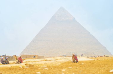 Giza, Mısır - 20 Aralık 2017: Eski cameleers oturup beklemek 20 Aralık Giza piramitleri ve Giza arkeolojik site binmek için bir müşteri için
