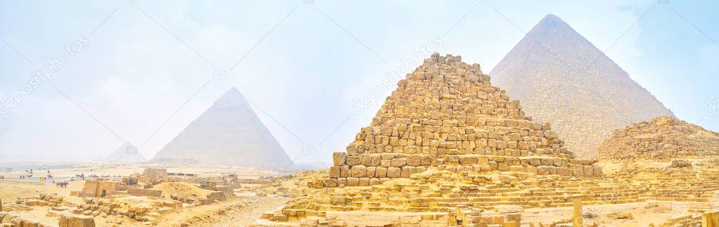 Panoramic view on Giza pyramids through heavy winter morning fog and sandy clouds, Egypt