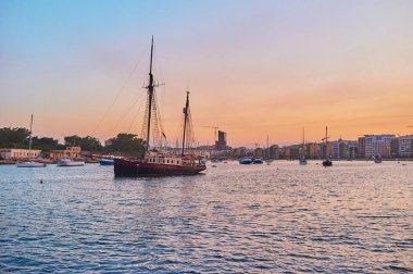 Vintage yelkenli gemi Valletta Manoel shore adanın Kuzey limanında dalgalar üzerinde sallanan, Sliema akşam cityscape bunun arkasında, Malta görülür.