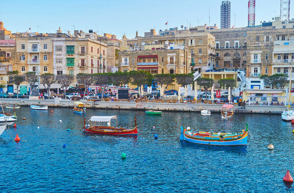 SENGLEA, MALTA - JUNE 18, 2018: The colorful wooden dghajsa water taxies are moored at the coast of L-Isla in waters of Vittoriosa marina, on June 18 in Senglea.