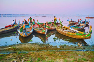 Mandalay, Myanmar - 21 Şubat 2018: Küçük liman Taungthaman göl günbatımı gezileri günü 21 Şubat Mandalay U olmak köprüye sunan çok sayıda renkli tekneler ile.