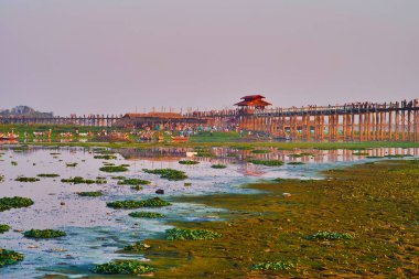 Göl, Amarapura, Myanmar Taungthaman Gölü silted banka teakwood U olmak köprü manzaralı ve turist tekneleri yürümek.