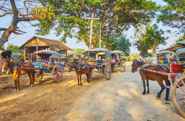 Ava, Myanmar - 21 Şubat 2018: Gölgeli sokak günü 21 Şubat Ava turistler için bekleyen çok sayıda vintage atlı arabaları ile dolu.