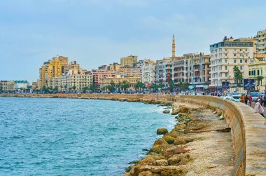 Alexandria, Mısır - 19 Aralık 2017: Kentsel şehir sahil yapılardır Corniche Bulvarı boyunca bir görünüm ve dalgaların üzerinde 19 Aralık İskenderiye Akdeniz deniz yüzeyi ile.