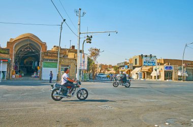 Yazd, Iran, 18 Ekim 2017: Sürüş bisiklet Imam Khomeini sokakta Khan'ın Bazaarı Ortaçağ portal üzerinde 18 Ekim Yazd içinde arka plan üzerinde bir görünüm ile.