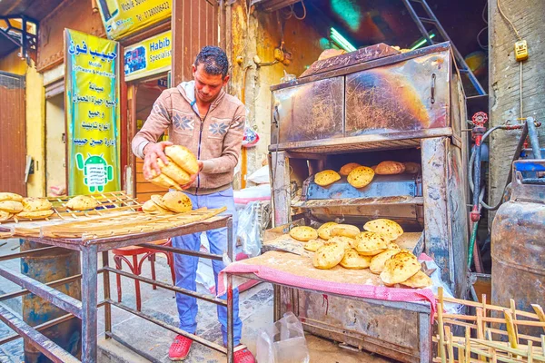 Cairo, Mısır - 20 Aralık 2017: Fırıncı 20 Aralık Kahire'de El Gamaleya street, Han El Halili çarşı, İslami Kahire, sıcak taze pide ekmek satıyor.