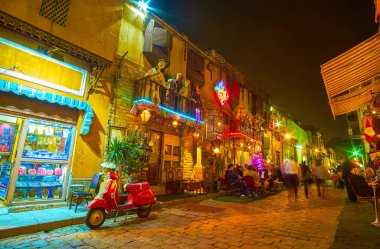 CAIRO, EGYPT - DECEMBER 20, 2017: Late evening is the most busiest time in old Cairo, crowds of locals walk along the streets, cafes and restaurants are full, on December 20 in Cairo. clipart