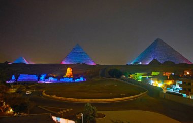 Giza Piramitlerine ve Büyük Sfenks renkli aydınlatma turistler arasında Mısır popüler akşam eğlence performansı üzerinde.