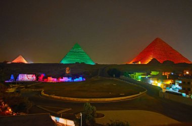 The light show in Giza Necropolis - bright lights on ancient Pyramids and Great Sphinx make this place one of the most interesting for evening visit, Cairo, Egypt. clipart