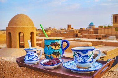 Ortaçağ adobe çatı geleneksel Cafe, çay, kahve ve tatlı tarihleri sunan el yapımı bardak ve kupalar, ilkel hayvansı desenler, Yezd, Iran ile dekore edilmiş kahve molası ve öğle yemeği zevk.