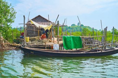 Chaung Tha, Myanmar - 1 Mart 2018: Balıkçı mangroves Kangy nehrinde küçük köyde 1 Mart Chaung Tha içinde ait küçük gecekondu stilts üzerinde oturan net onarır.