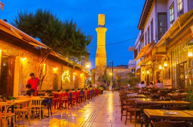 Antalya, Türkiye - 9 Mayıs 2017: Dar sokağa Restoran açık teraslar ile kaplı olduğu, kırık minare Kesik Minare caminin arka planda, 9 Mayıs Antalya görülür.