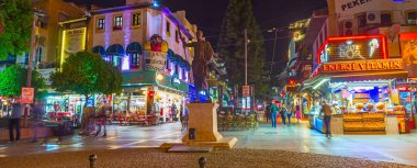 Antalya, Türkiye - 9 Mayıs 2017: Attalos II heykel manzaralı akşam Cumhuriyet Meydanı ve açık hava kafeleri ile uzun yürüyüş sokak, Hediyelik eşya mağazaları ve sokak gıda arkasında 9 Mayıs Antalya tezgahları.