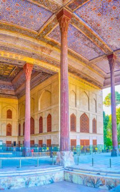The unique decoration of wooden frontage gallery with high carved cedar pillars and painter ceiling of Chehel Sotoun Palace in Isfahan, Iran clipart