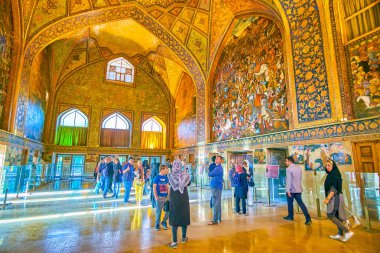 İsfahan, İran - 19 Ekim 2017: Turistler 19 Ekim'de İsfahan'da Çehel Sotoun Sarayı'nın muhteşem dekorasyonlarının keyfini çıkararken ana salonda yürüyorlar.
