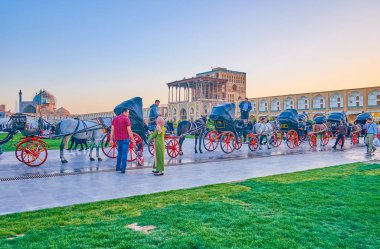 ISFAHAN, IRAN - OCTOBER 19, 2017: Ride in traditional corse drawn carriage in Nashq-e Jahad Sqaure is the best way to feel the spirit of the past, on October 19 in Isfahan