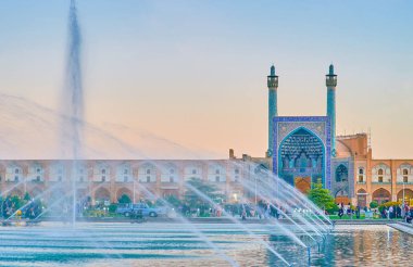 ISFAHAN, IRAN - OCTOBER 19, 2017: The amazing ensemble of Nashq-e Jahad Sqaure with Shah's Mosque, covered galleries on the sides and huge fountain in the middle of the square, on October 19 in Isfahan