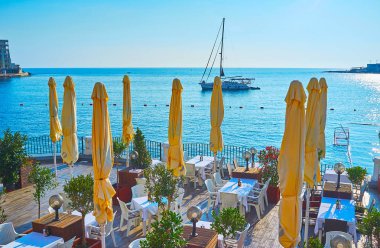 St Julians, Malta - 20 Haziran 2018: 20 Haziran'da St Julians'da, ön planda güzel açık hava restoranı ile şehrin kıyısından pitoresk deniz manzarası.