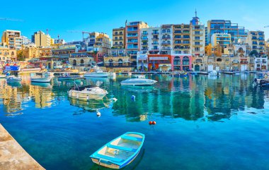 St Julians, Malta - 20 Haziran 2018: Spinola Bay harbour berrak masmavi yüzeyine modern binalar yansıtır ve tekneler, 20 Haziran St Julians içinde demirleyen.