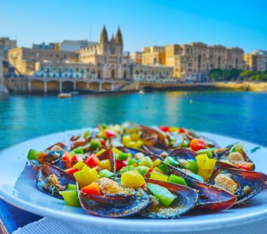 Taze deniz ürünleri yemek için mükemmel seçimdir, Balluta koyunda restoran bulunmaktadır peynir, sebze ve Carmelite Kilisesi, St Julian's, Malta bir görünüm ile kokulu otlar ile taze midye.