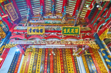 YANGON, MYANMAR - FEBRUARY 17, 2018: Details of interior of Long Shan Tang Clan Temple with many beautiful scroll boards, carved and painted wooden parts, on February 17 in Yangon.