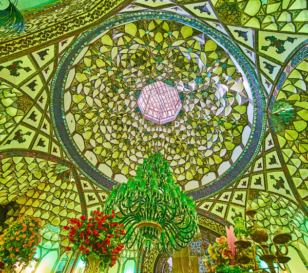 ISFAHAN, IRAN - OCTOBER 21, 2017: The complex dome of Mohammad Bagher Shafti Mausoleum of Seyed Mosque with muqarnas decoration and old-styled green glass chandelier, on October 21 in Isfahan.