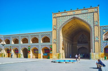Isfahan, Iran - 21 Ekim 2017: günü 21 Ekim Isfahan tarihi madraseh (İlahiyat Okulu), kemerli galeriler tarafından çevrili görünüm üzerinde onun avlu (çelik), Jameh Camii güzel Kuzey portalı.