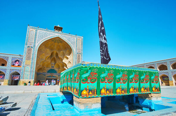 ISFAHAN, IRAN - OCTOBER 21, 2017: The sahn (courtyard) of Jameh Mosque is decorated with Ashura flags and surrounded by historic buildings, on October 21 in Isfahan.