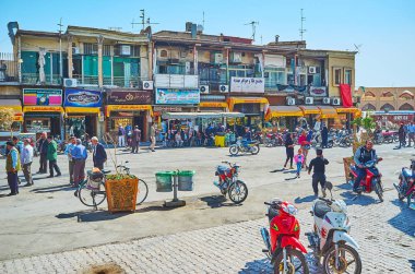 Isfahan, Iran - 21 Ekim 2017: Mağazalar ve kafeler günü 21 Ekim Isfahan Ortaçağ Qeysarie (Soltani) çarşı yanında kalabalık sokakta eski püskü binalarla satır.