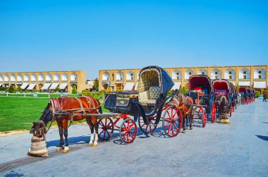 Turist arabaları Nakş-ı Cihan Meydanı ile ortasında sıra kemerli Galeri og (Soltani) kapalı çarşı arka planda, Isfahan, Iran.