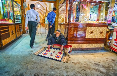 Isfahan, Iran - 21 Ekim 2017: günü 21 Ekim Isfahan (Soltani, Qeysarie) Grand Bazaar, Takı Mağazaları yanında katta oturan yaşlı tüccar teklifler küçük yün halılar,.