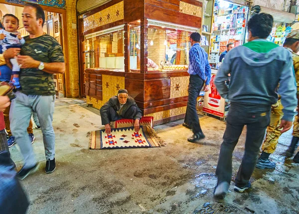Isfahan, Iran - 21 Ekim 2017: Üst düzey halı satıcı Grand (Soltani, Qeysarie) ın Bazaarı kalabalık alleyway yerde oturur ve ilkel desenli geleneksel yün halı günü 21 Ekim Isfahan sunar.
