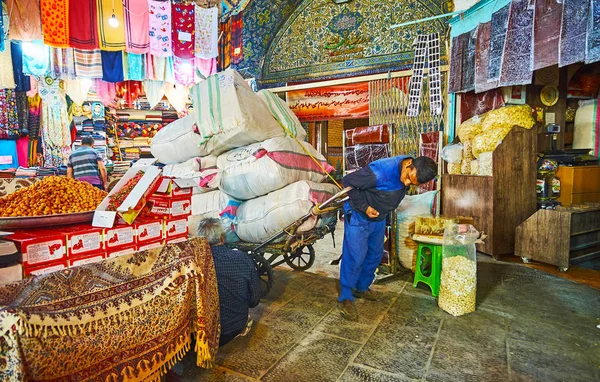 Isfahan, Iran - 21 Ekim 2017: Kapıcı günü 21 Ekim Isfahan (Soltani, Qeysarie) Grand Bazaar, sıkı alleyway boyunca büyük çanta ile ağır aşırı yüklenmiş arabası taşır.