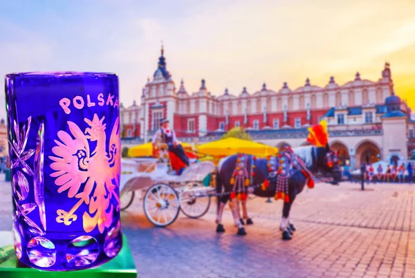 Enjoy the view on horse-drawn carriages in the Main Market square, sitting in outdoor restaurant against the medieval Cloth Hall with glass of Polish vodka,  Krakow, Poland.