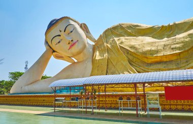 Mya Tha Lyaung Buda Tapınağı, Bago, Myanmar yeşil bahçesi ile çevrili büyük yatan Buda görüntü dolaşmak.