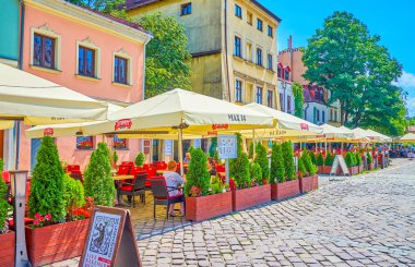 Krakow, Polonya - 21 Haziran 2018: Hat yaz teras ile büyük umbrelas Szeroka street, tarihsel Kazimierz bölgesinde, 21 Haziran Krakow popüler turistik Restoran