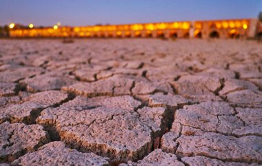 Siosepol Köprüsü'nde parlak akşam ışıklar arka planda, Isfahan, İran'ın bir manzaralı Zayanderud nehir üzerinde kırık çamur close-up.