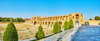 Çıkabilir Zayandeh Nehri (Zayanderud) kurutulmuş taze yeşillik Abshar park ve Ortaçağ tuğla arka planda, Isfahan, Iran Khaju Köprüsü manzaralı yürüyüş.