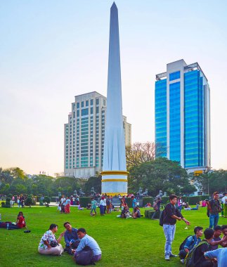 Yangon, Myanmar - 15 Şubat 2018: Yerli Maha Bandula bahçede çim bir görünüm Bağımsızlık Anıtı ve arka planda 15 Şubat Yangon modern binalarıyla oturup piknik keyfini çıkarın.