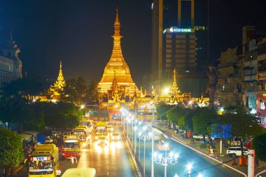 Yangon, Myanmar - 15 Şubat 2018: Akşam görünümünü Sule yol çok sayıda toplu taşıma otobüsleri ve büyük altın parlak ışıklı stupa Sule Paya, arka plan üzerinde 15 Şubat Yangon.
