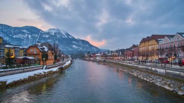 Bad Ischl, Avusturya - 20 Şubat 2019: Bulutlu gün batımı gökyüzü Alpler üzerinde 20 Şubat Bad Ischl içinde ön plan, Traun Nehri'nin kıyısında üzerinde geleneksel Salzkammergut konut ile yukarıda. 