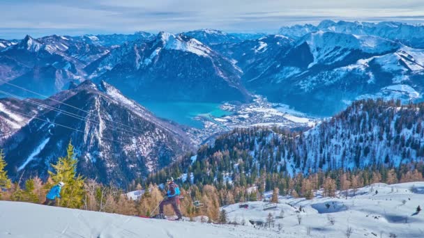 ピークの Feuerkogel Alp ダッハシュタイン山塊の積雪のコーンを見下ろす スキー ゲレンデとバレー Ebensee オーストリアのザルツカンマーグートのトラウンゼー湖斜面 — ストック動画