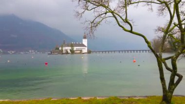 Ağır yağmurlu bulutlar ve gri sis kapsar Traunsee Gölü, Salzkammergut, Avusturya arasında küçük adacık üzerinde bulunan Alp dağ silsilesi üstün Schloss Ort Kale arkasında. 