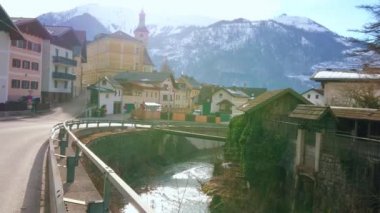 Ischlerstrasse sokak, şehir konut, Parish Kilisesi ve karlı Alp Ebensee, Salzkammergut, Avusturya arka plan üzerinde çan kulesi manzaralı Traun Nehri'nin tepelik setin yürümek. 