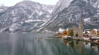 Arka planda, Salzkammergut, Avusturya uzun boylu spire Protestan Parish Kilisesi ve Dachstein Alpler manzaralı Hallstatt eski şehirden Feribot Seferi.