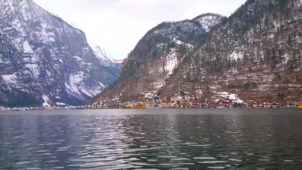 その土手に沿って表面と巨大なダッハシュタイン アルプスの波紋と Hallstattersee 湖のパノラマ ハルシュタットの町のカラフルな建物は ザルツカンマーグート オーストリア サルツバーグ山の麓で見られています — ストック動画