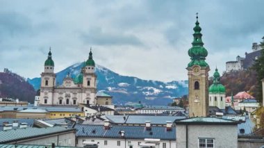 Eski şehir, Salzburg dağlar, Avusturya havering Katedrali, St Peter's Abbey ve yağmurlu bulutlar, uzun çan kulesi Barok cephe çatı Monchsberg tepenin yamacında bakan. 