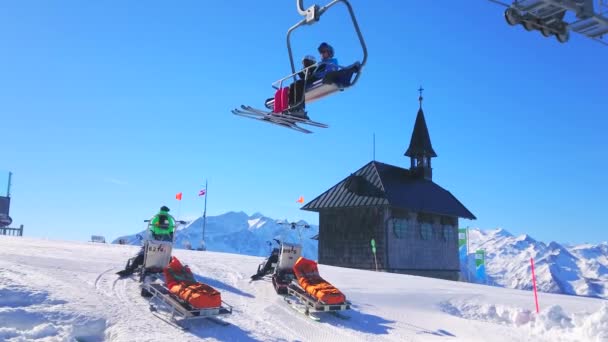 ツェル オーストリア 2019 シュミッテンヘーエ山の積雪斜面マウント木製エリザベス礼拝堂 救助そりと 日ツェル ゼーのリフトに乗って上のビュー — ストック動画