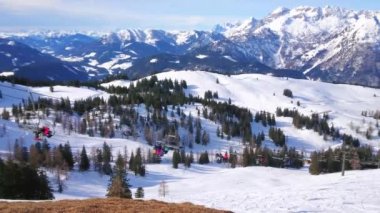 Hızlı sürme telesiyej sporcular, Zwieselalm, Gosau, Salzkammergut, Avusturya tepesine gidiş ile bir görünüm ile kar ve çam ormanları ile kaplı Dachstein Batı Alplerdeki sahne alarak nefes