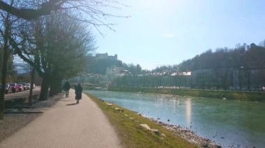 Elizabeth dolgu partnerliğindeki Nehri boyunca bir yürüyüş kaplı Hohensalzburg Kalesi (Salzburg Kalesi) ön plan, yüksek Festungsberg tepede manzaralı gölgeli ağaçlar ile Salzburg, Avusturya.